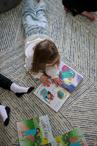 Child playing with books on a carpeted floor