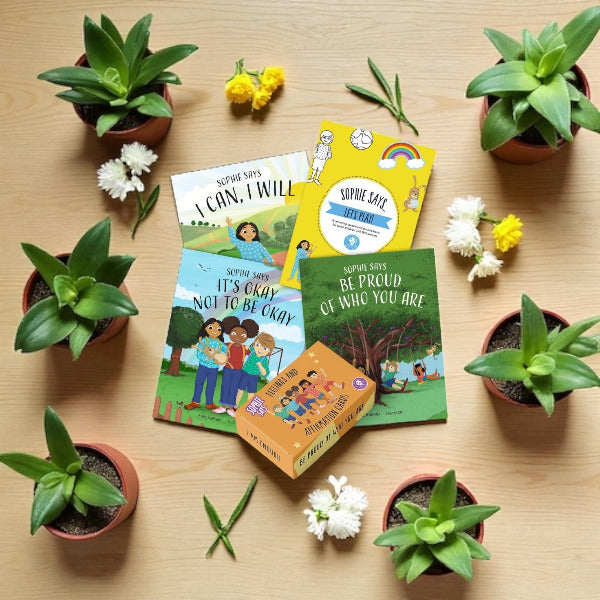 Sophie Says books on a wooden surface with potted plants and flowers